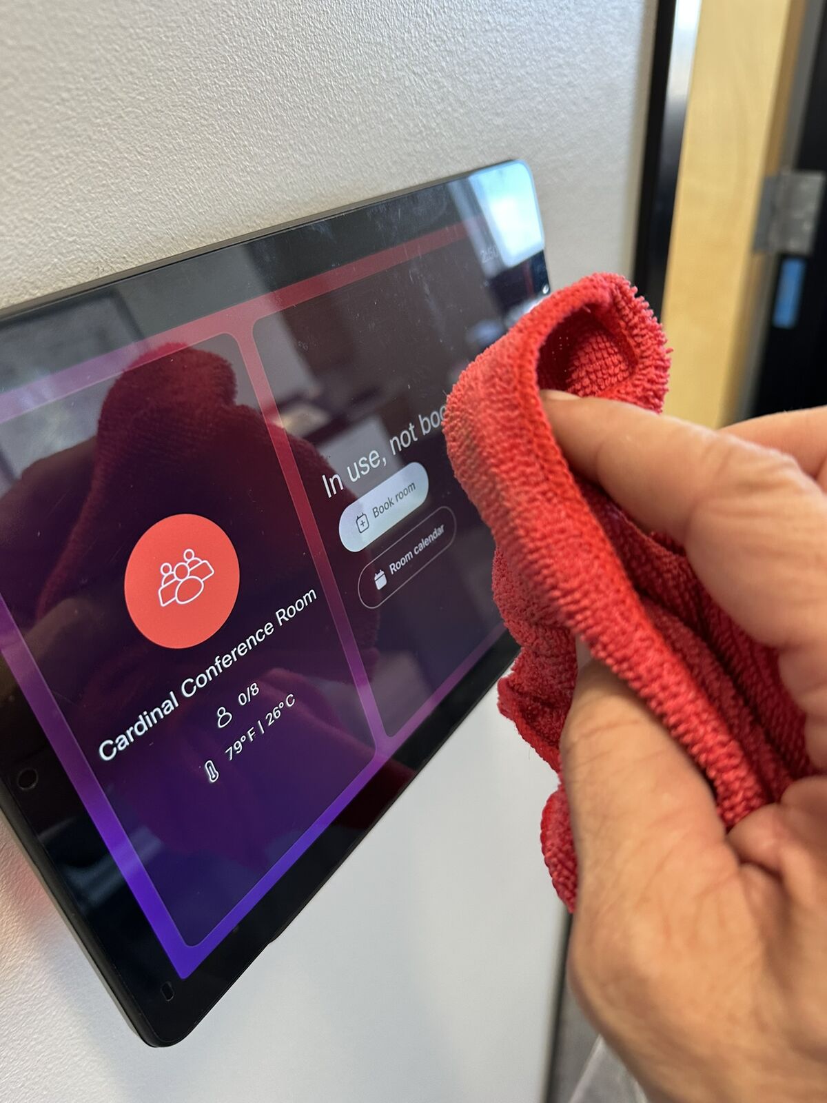 Shared warehouse touchscreen being cleaned with microfiber cloth