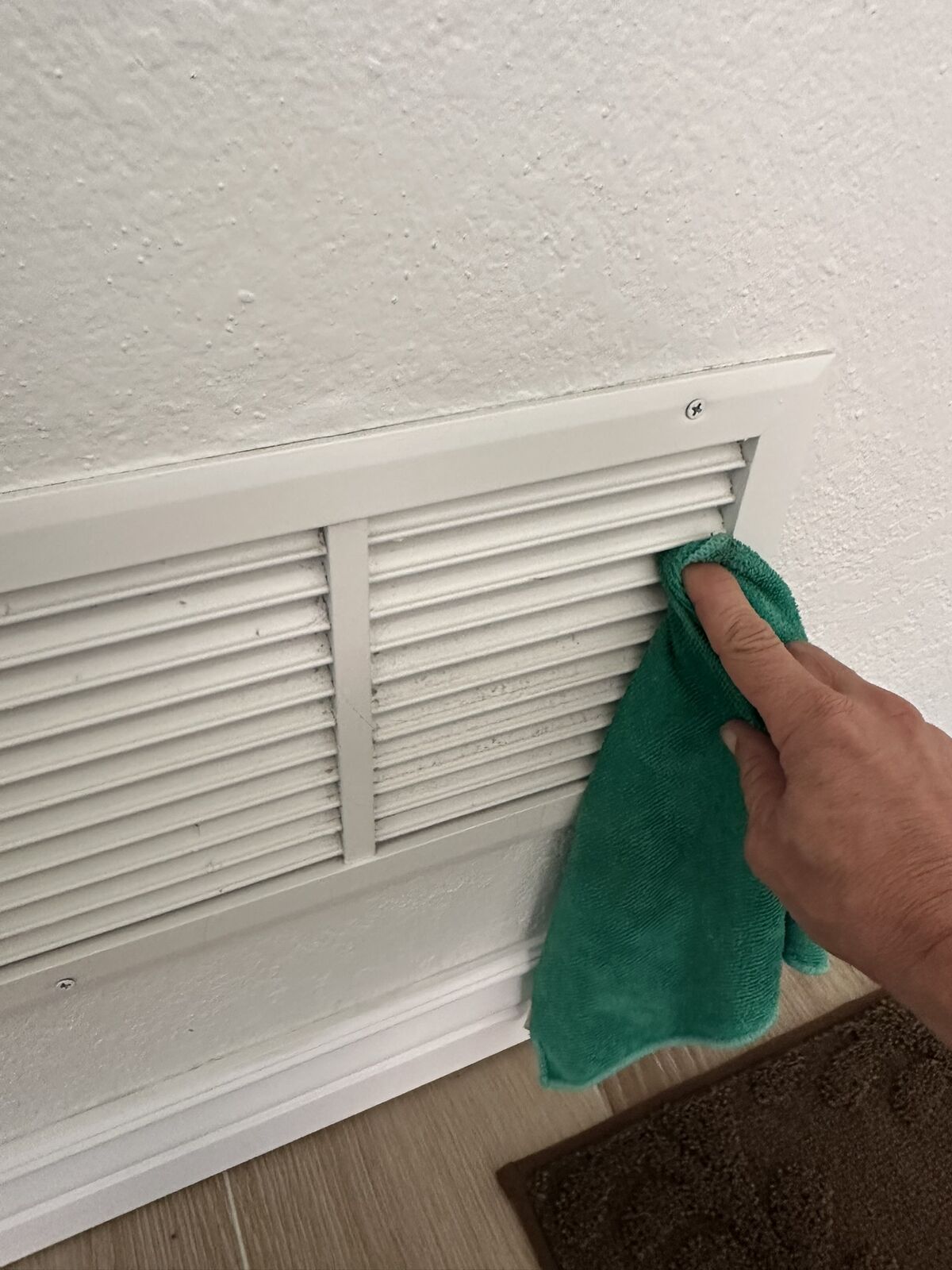 Fresh Care Cleaning wiping air return vent slats in Mesa rental
