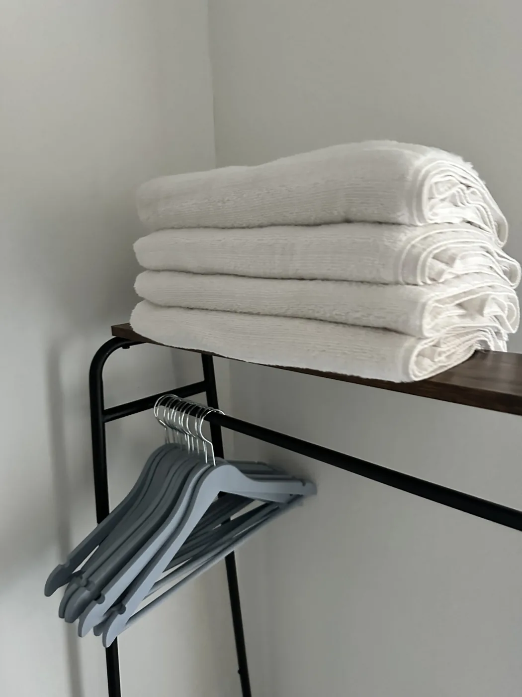 Folded white towels and organized hangers