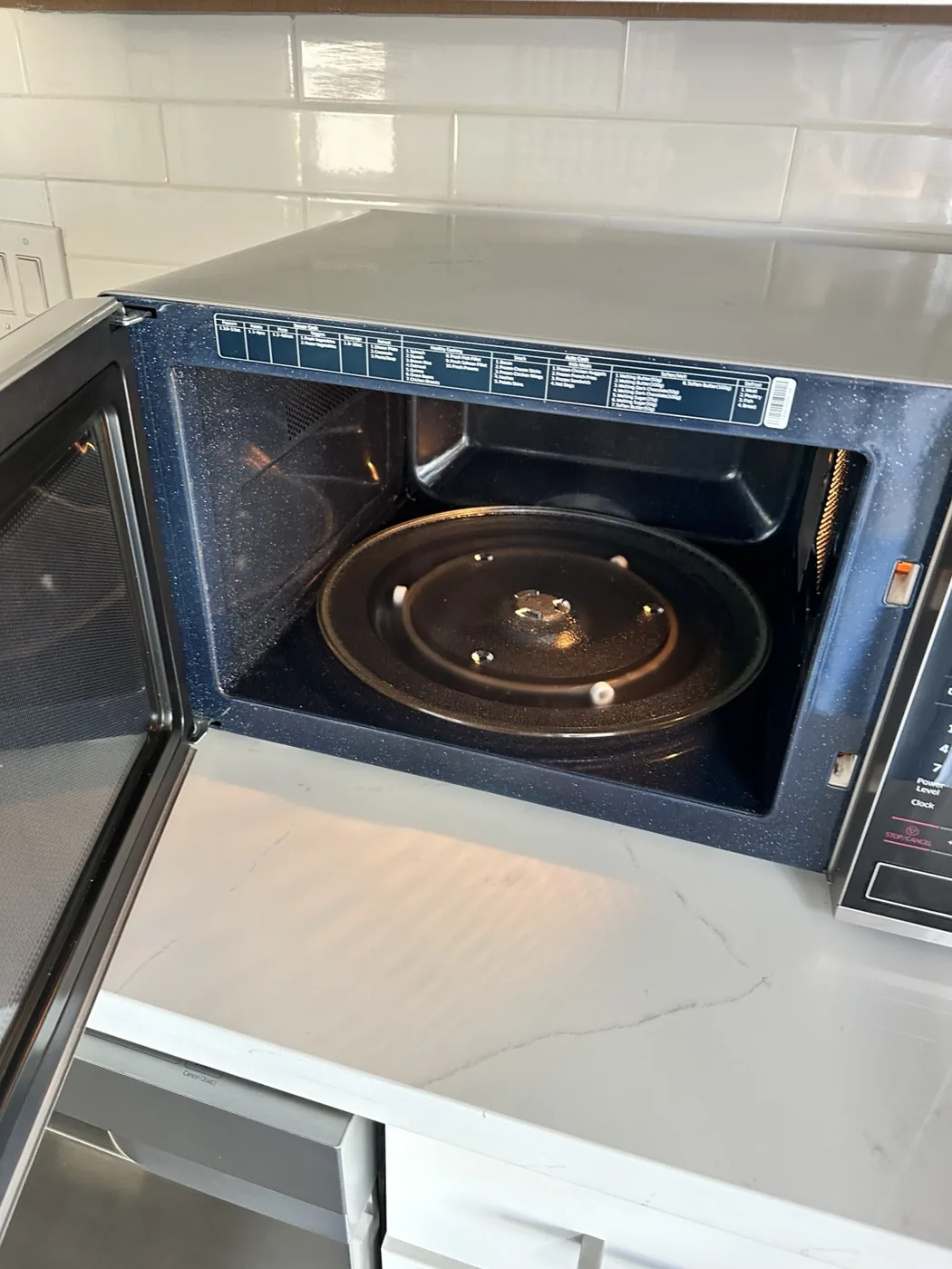 Open microwave interior inspected for cleanliness